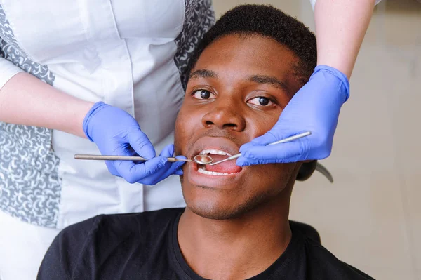 Paciente varón africano recibiendo tratamiento dental en clínica dental — Foto de Stock