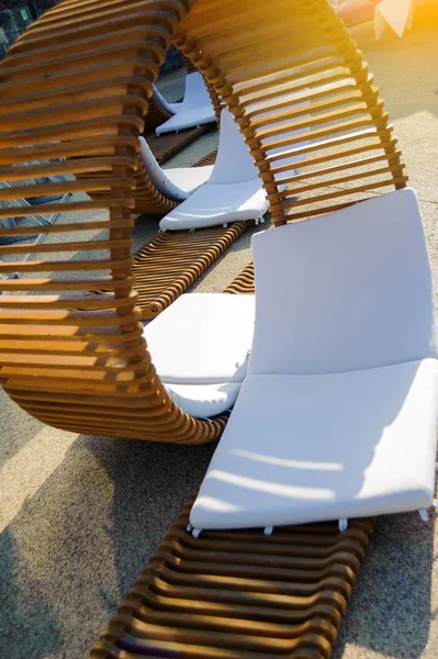 Chaise longue de madera inusual cerca de la piscina —  Fotos de Stock