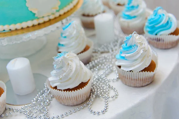 Cupcakes azuis e brancos no prato na mesa de doces — Fotografia de Stock