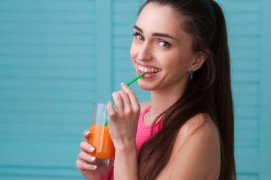 Bir bardak meyve suyuyla gülümseyen kadın.