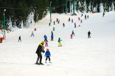 Skiers and snowboarders going down the slope at Donovaly ski res