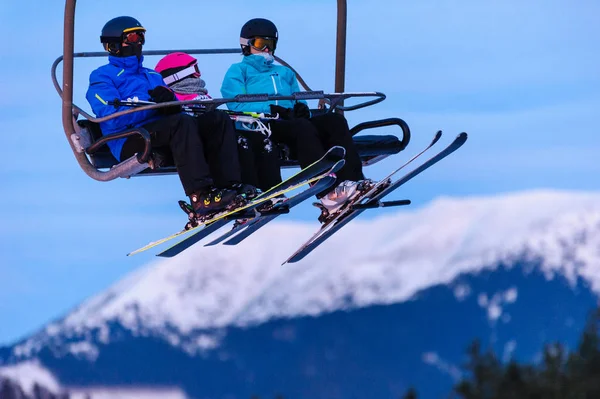 Skiers on chair lifts in the evening — Stock Photo, Image