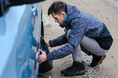 Bir adam arabanın tekerleğini kırdı ve kendi başına değiştirdi.