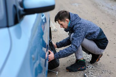 Bir adam arabanın tekerleğini kırdı ve kendi başına değiştirdi.
