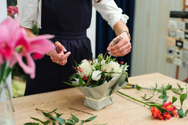 Gardener's in the flower shop make bouquet. Lifestyle flower sho