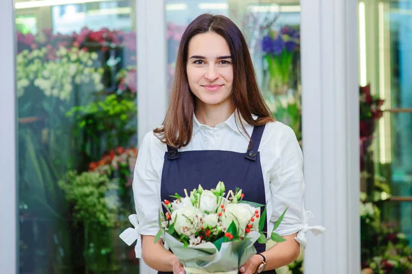 El dueño de una florería hace un ramo con rosas blancas — Foto de Stock