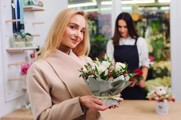 Flower shop owner sells a bouquet of white roses to a buyer