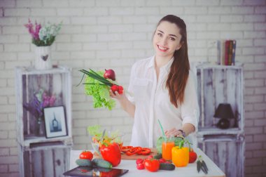 Güzel kız mutfağında taze sebze salatası hazırlıyor.