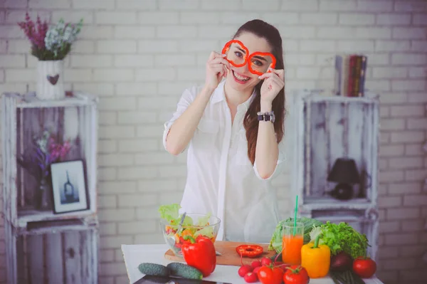 Csinos lány friss zöldségsalátát készít a konyhájában. — Stock Fotó