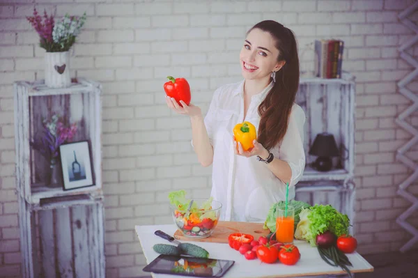 Csinos lány friss zöldségsalátát készít a konyhájában. — Stock Fotó