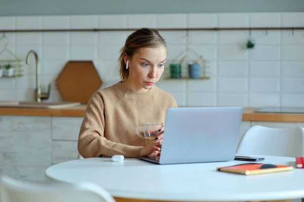 Mujer Rubia Encantadora Trabajando Con Portátil Mientras Está Sentada Cocina — Foto de Stock