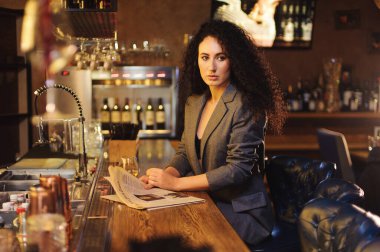 Takım elbiseli şık bir bayan, bir barda tek başına.