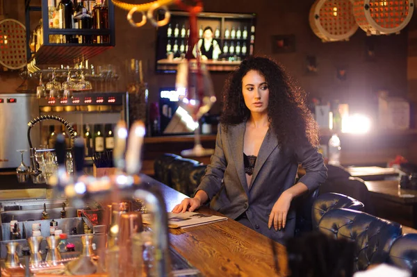 Elegant lady in a business suit, in a restaurant at a bar counter alone
