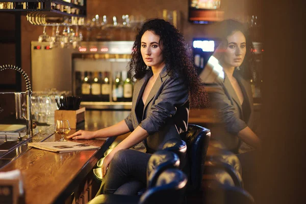 穿着西装的优雅女士一个人在酒吧柜台的餐厅里 — 图库照片