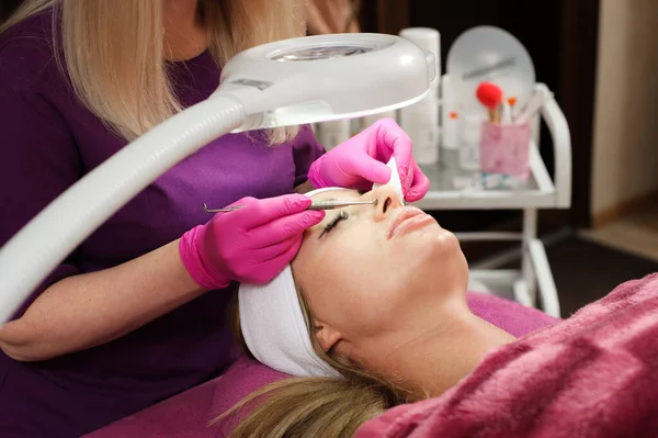 Woman in the professional beauty salon during a mechanical face cleansing procedure