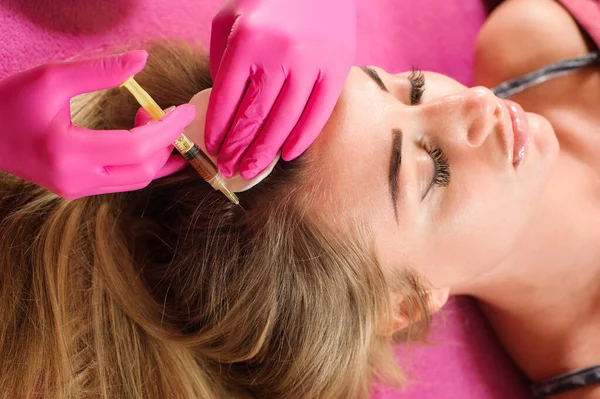 Needle mesotherapy. Cosmetic been injected in woman\'s head. Thrust to strengthen the hair and their growth