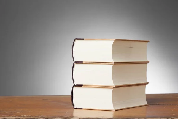Drie boeken over een houten tafel — Stockfoto