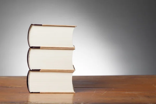 Drie boeken over een houten tafel — Stockfoto