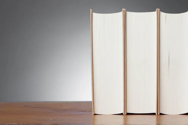 Drie boeken over een houten tafel — Stockfoto