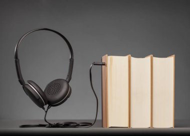 Bir kulaklık, sesli kitap için kavram ile gri arka plan üzerine kitaplar Vintage