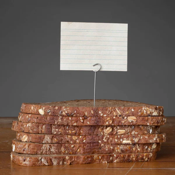 Malé série, porovnávání potravin - tmavý chléb s malým prázdný štít / přihlásit — Stock fotografie
