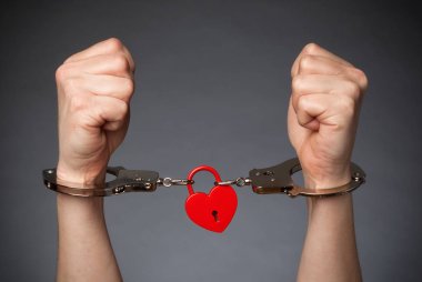 Kırmızı kalp kilit ve bir çift el Handcufs: aşk tarafından yakalanan