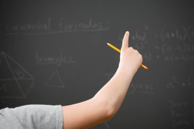 Sınıfta bir soru sormak için genç kişi kolunu yetiştirme.