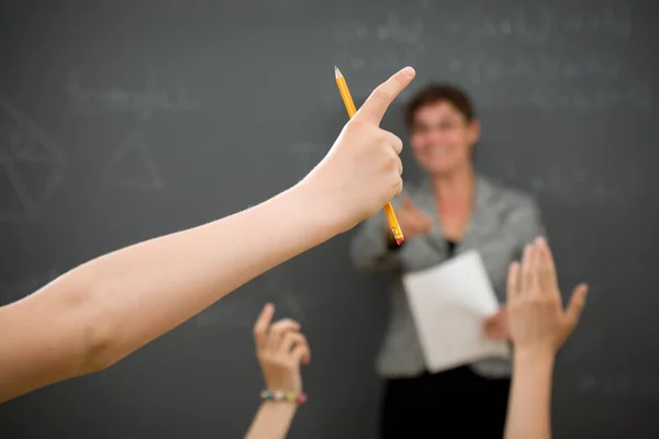 Young person raising his arm to ask a question in the Classroom. — Stock Photo, Image