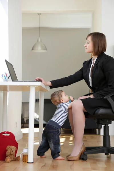 Прекрасна молода працююча мати і її дитина, в її домашньому офісі, наполегливість — стокове фото