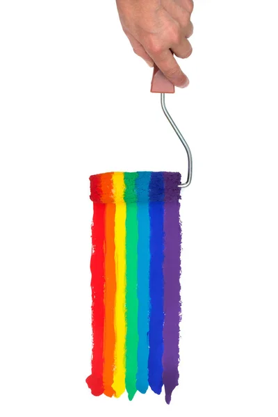 Mano sosteniendo un rodillo de pintura, pintando colores del arco iris sobre un fondo blanco aislado —  Fotos de Stock