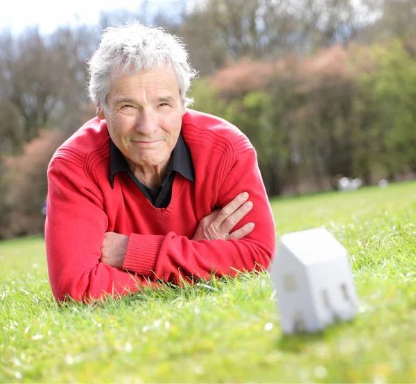 Serie een gelukkig Senior pensioen-of rentetrekker, verbeelden zijn nieuwe toekomstige huis met een beetje papier-huis — Stockfoto