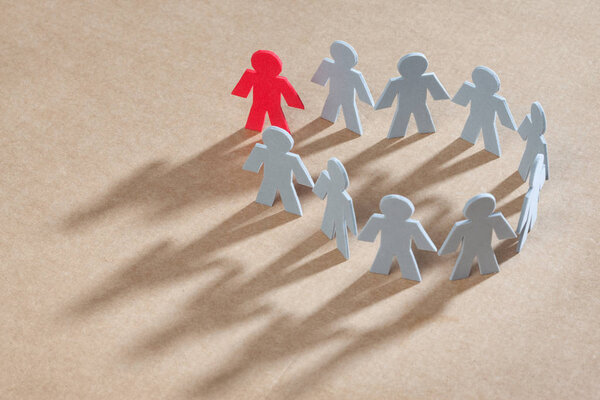 Маленькие люди, включая незнакомца на картонном фоне
