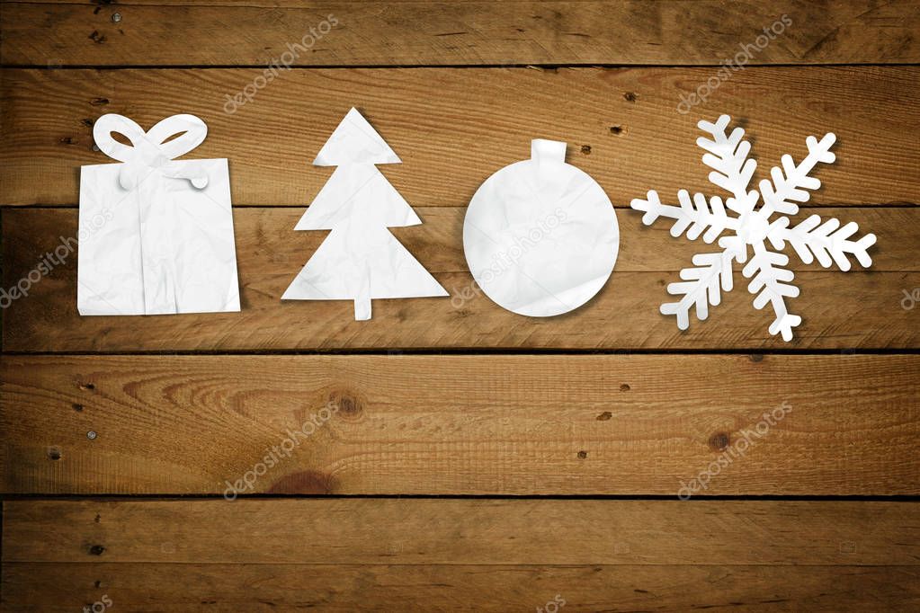 Christmas Paper Ornaments, Merry Christmas on a wood table background: Cute little paper cut outs of christmas decoration items, Gift, Tree, Bauble and Snowflake