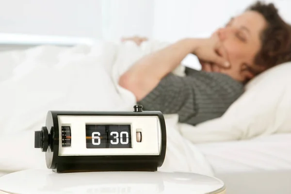 Relógio de alarme vintage definido às 6: 30 da manhã, muito cedo para a mulher ainda dormindo — Fotografia de Stock