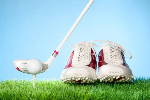 Sérii golfové vybavení koncept obrázků. Výstřel ve studiu na trávě s modrým pozadím: boty na Golf, míček na Tee a Club — Stock fotografie