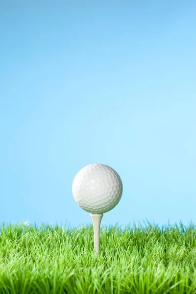 Série de imagens conceito de equipamento de golfe. Tiro em estúdio na grama com fundo azul: Bola no Tee com espaço de cópia — Fotografia de Stock