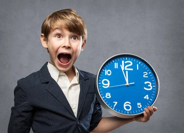 Happy Surprised 7 Year old Boy, Holding a blue Big Clock, just minutes before midnight: either, he is warning us that time is running out, or ready to celebrate New Year — Stock Photo, Image
