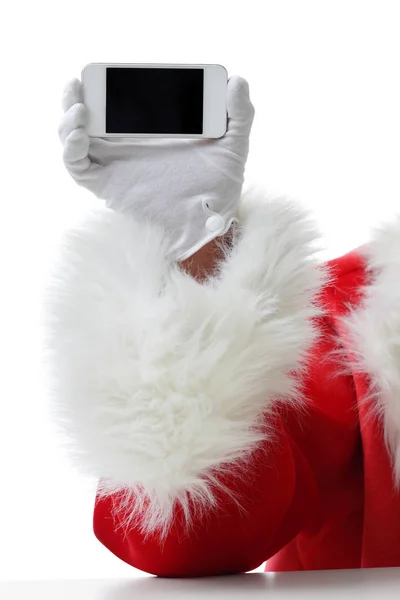 Jul-konceptet sköt med Santa hålla en vit smart telefon isolerade på vit — Stockfoto