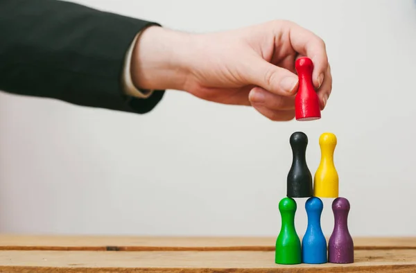 Business Team Building, diversiteit. Kleurrijke pionnen vorming van een piramide, vertegenwoordigen van vertrouwen — Stockfoto