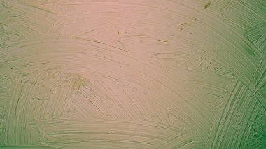 A close-up texture background of a distressed relief green red orange wall painted with wide strokes