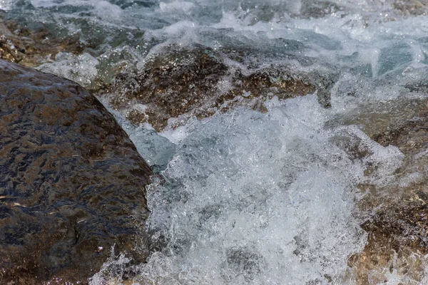 Gros plan d'une vague éclaboussant les rochers de la cascade de la rivière de montagne : plan plein cadre en stop motion — Photo