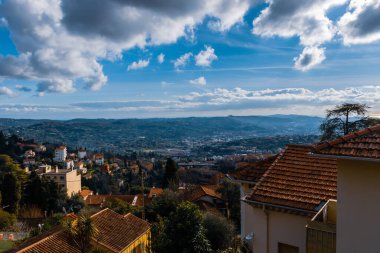 Cote d 'Azur şehir merkezinin panoramik şehir manzarası ve Akdeniz kıyısındaki Alpler dağları mavi bulutlu gökyüzünün altında (Grasse, France)