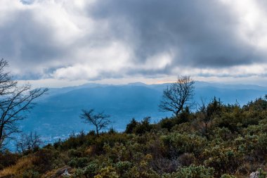 Cote d 'Azur Alpleri' nin bulutlu gökyüzünün altındaki panoramik manzarası ve ufuktaki Akdeniz kıyısı.