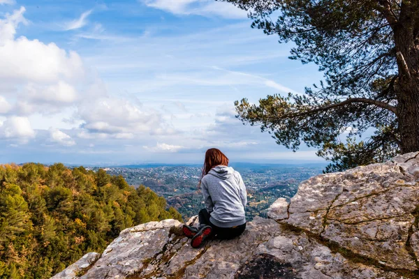 アルプスの山々や建物の景色を眺めながら崖の端に座っている若い赤毛の女性ハイカーのバックビュー Cote Azur — ストック写真