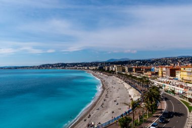 Quai des Etats-Unis 'in geniş açılı panoramik görüntüleri, Akdeniz kıyılarında dinlenen insanlar ve turkuaz suya yansıyan güneş ışığı (Güzel, Fransa)