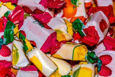 Paketlerinde meyve aromalı çeşitli çiğneme tatları olan bir yığın yakın çekim.