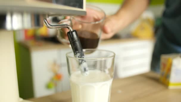 Cappuccino maken: voorbereiding van de warme melk schuim en gieten van koffie in het — Stockvideo