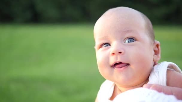 Bebé de ojos azules sonriendo y riendo en brazos femeninos. Yandheld disparo — Vídeos de Stock