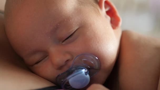 Drowsy little kid with baby dummy on mothers chest. Close up sloq motion — Stock Video