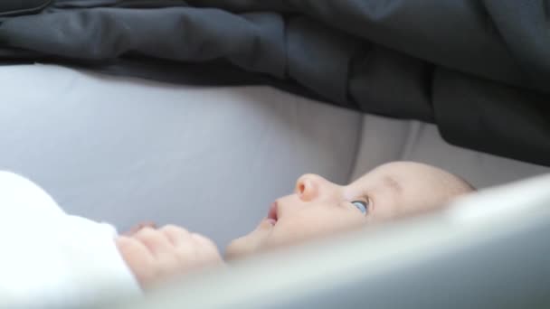 Moeder haar zoon liggen in een kinderwagen kussen — Stockvideo